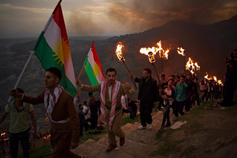 People celebrate Newroz, the Kurdish New Year, by carrying torches and flags up a hill, a traditional symbol of resistance and hope for the Kurdish people.
