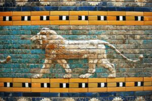 Day Tour Babylon from Karbala A detailed depiction of a striding lion in relief on an ancient wall made of colorful, glazed bricks.