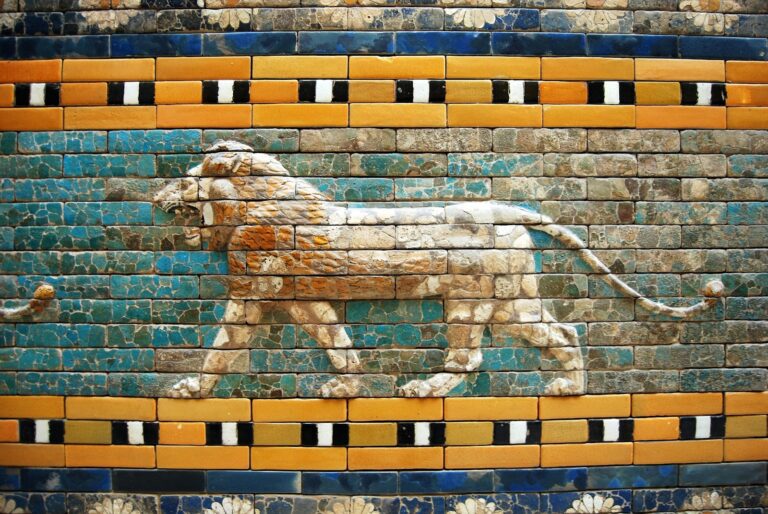 A detailed depiction of a striding lion in relief on an ancient wall made of colorful, glazed bricks.